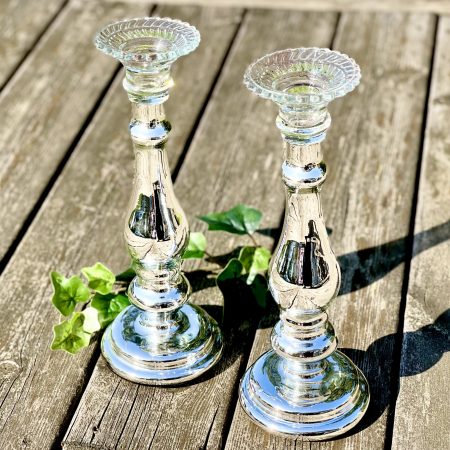 Två ljusstakar av silverfärgat glas