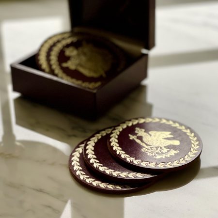 Glasunderlägg i läder med präglat motiv