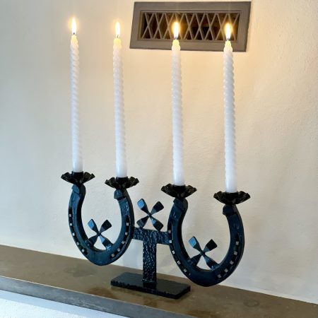 Ljusstake av svartmålat järn med hästskor och hästskosöm